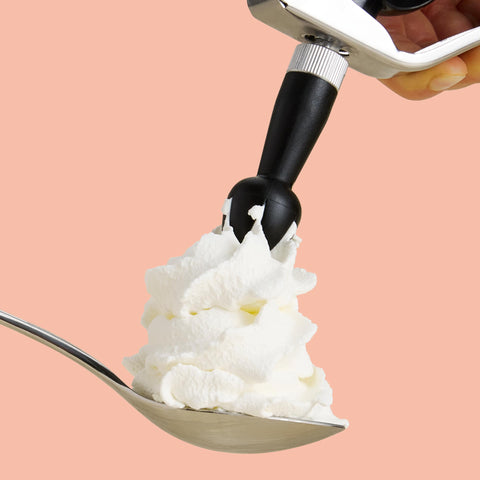 A CreamRight whipped cream dispenser adding whipped cream to a spoon